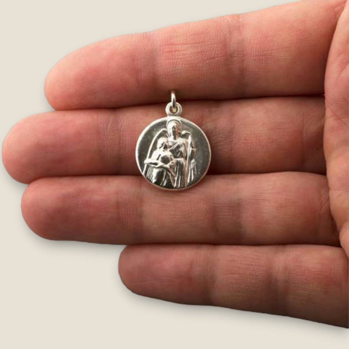 Medalla del Arcángel Rafael en plata - sobre una mano