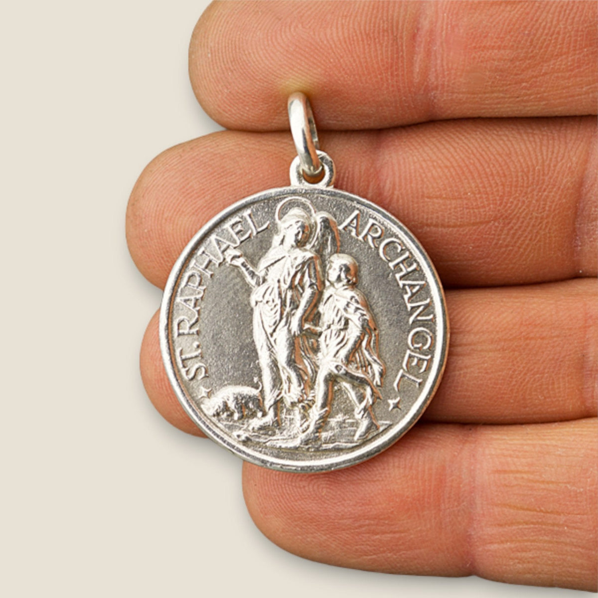 Medalla del Arcángel Rafael y San Cristóbal en plata - sobre una mano
