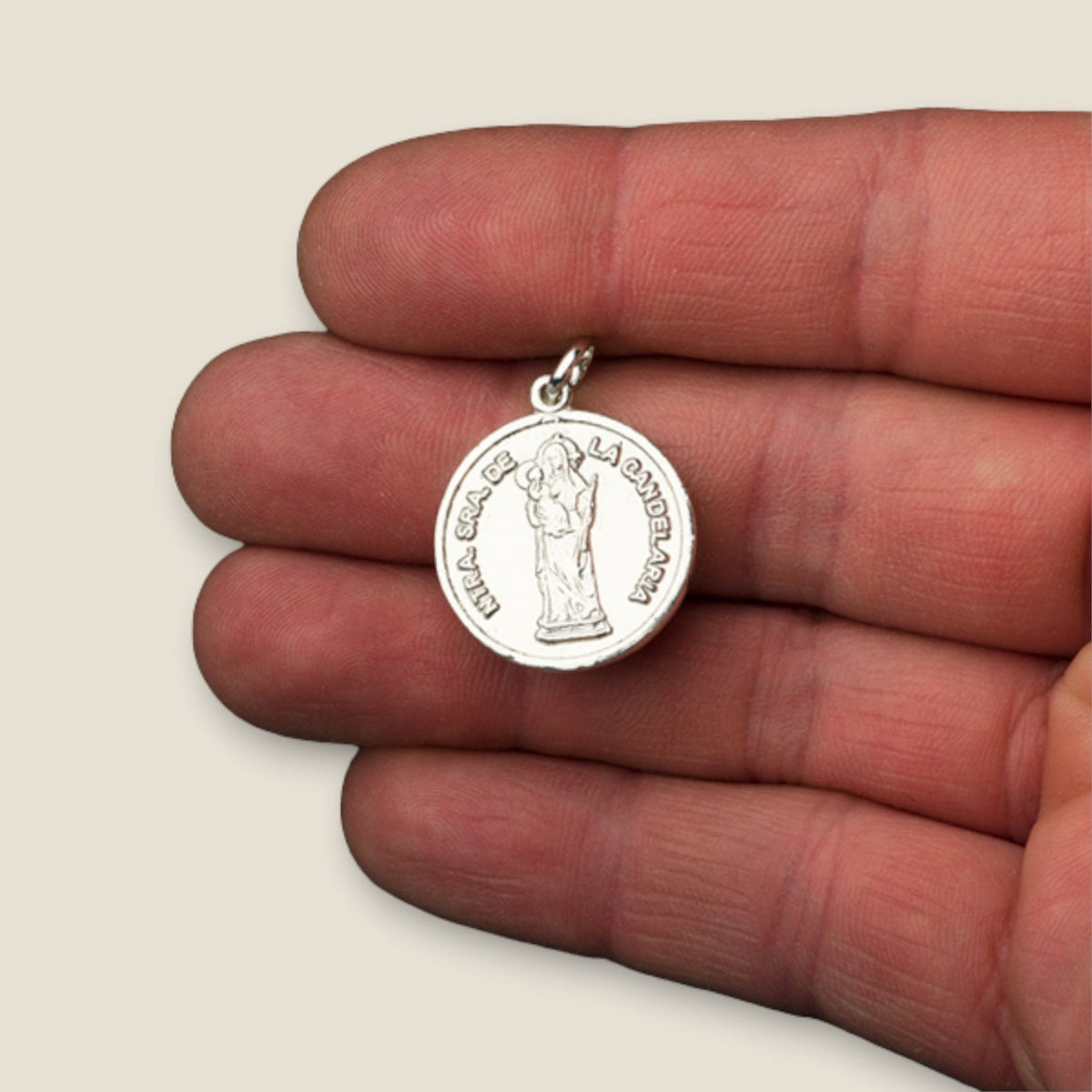 Medalla de la Virgen de la Candelaria en plata - sobre una mano