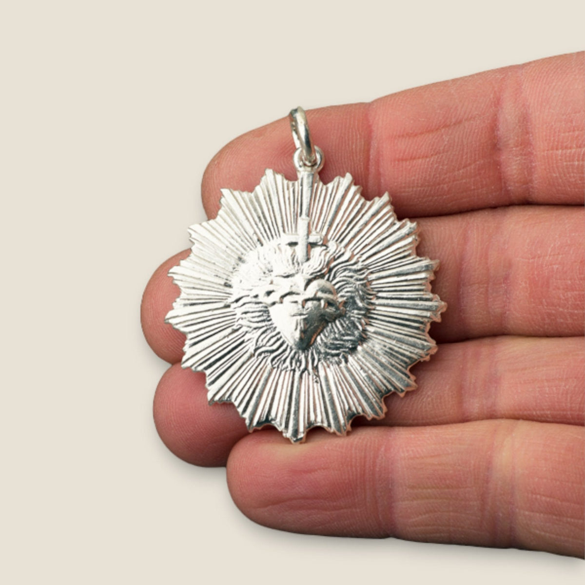 Medalla del Sagrado Corazón de Jesús en plata - sobre una mano