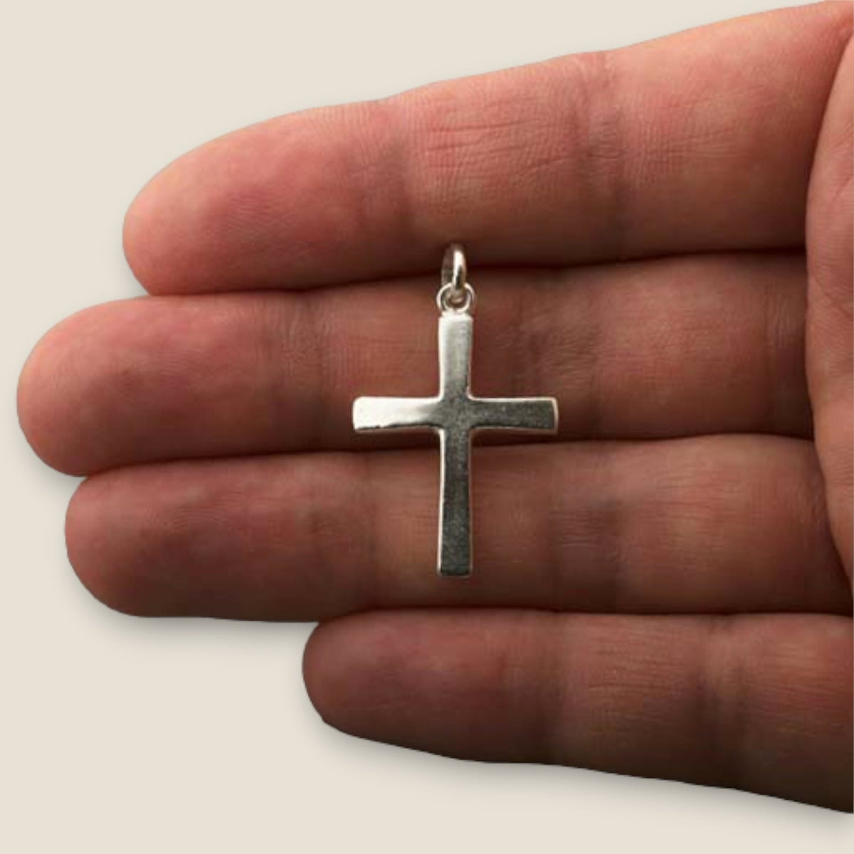 Cruz de plata - sobre una mano