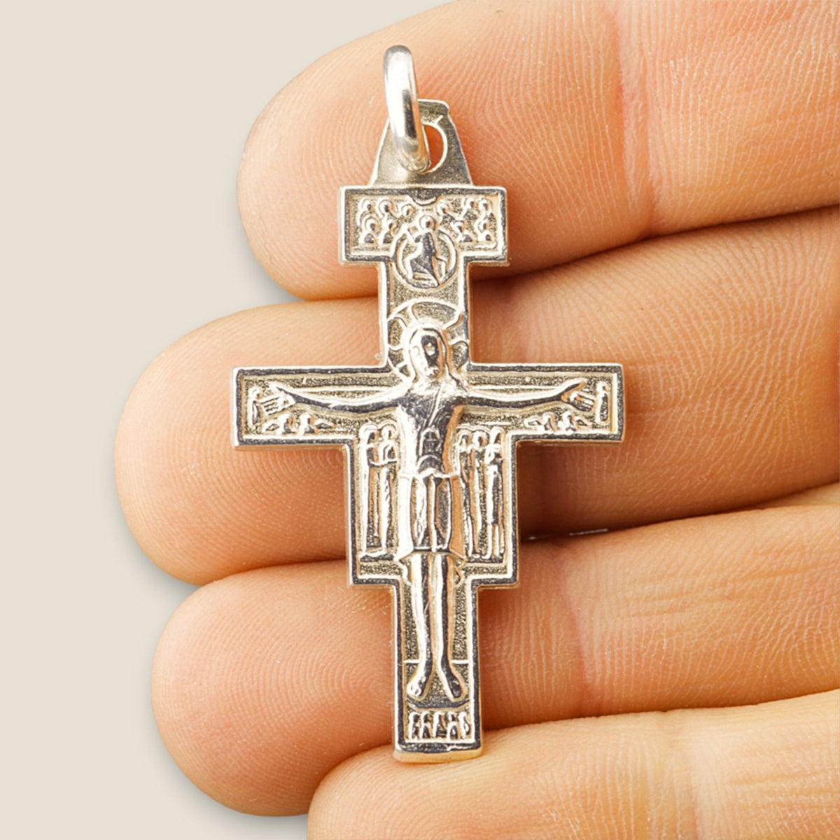 Cruz de San Damián en plata - sobre una mano