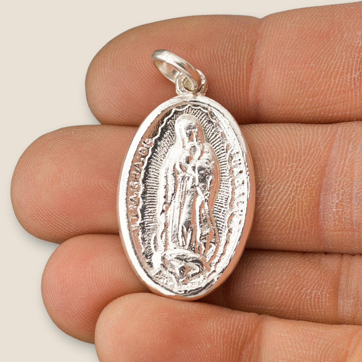 Medalla de la Virgen de Guadalupe en plata - sobre una mano