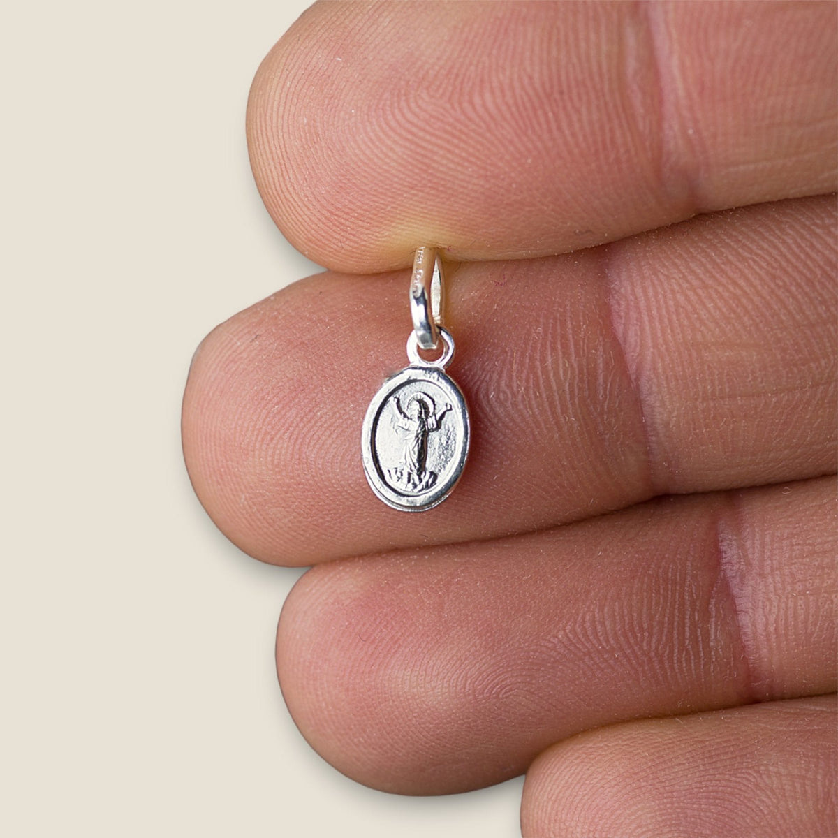 Medalla del Divino Niño en plata - tamaño pequeño sobre una mano