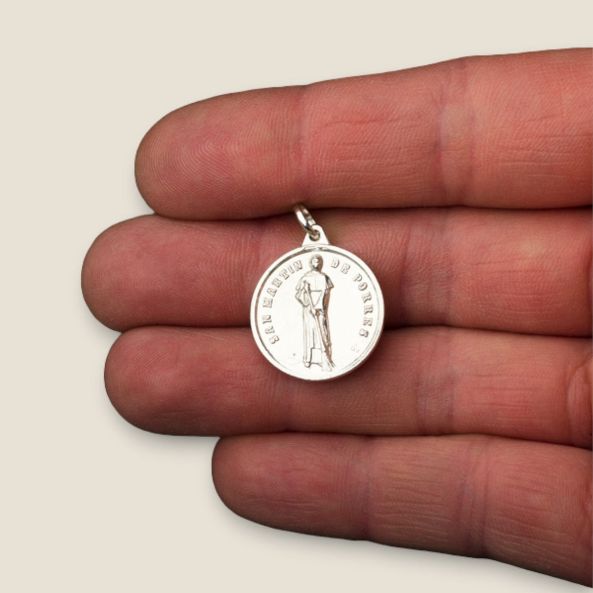 Medalla de San Martín de Porres en plata - sobre una mano