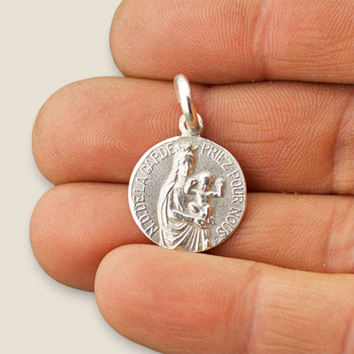 Medalla de la Virgen de la Guardia en plata - sobre una mano