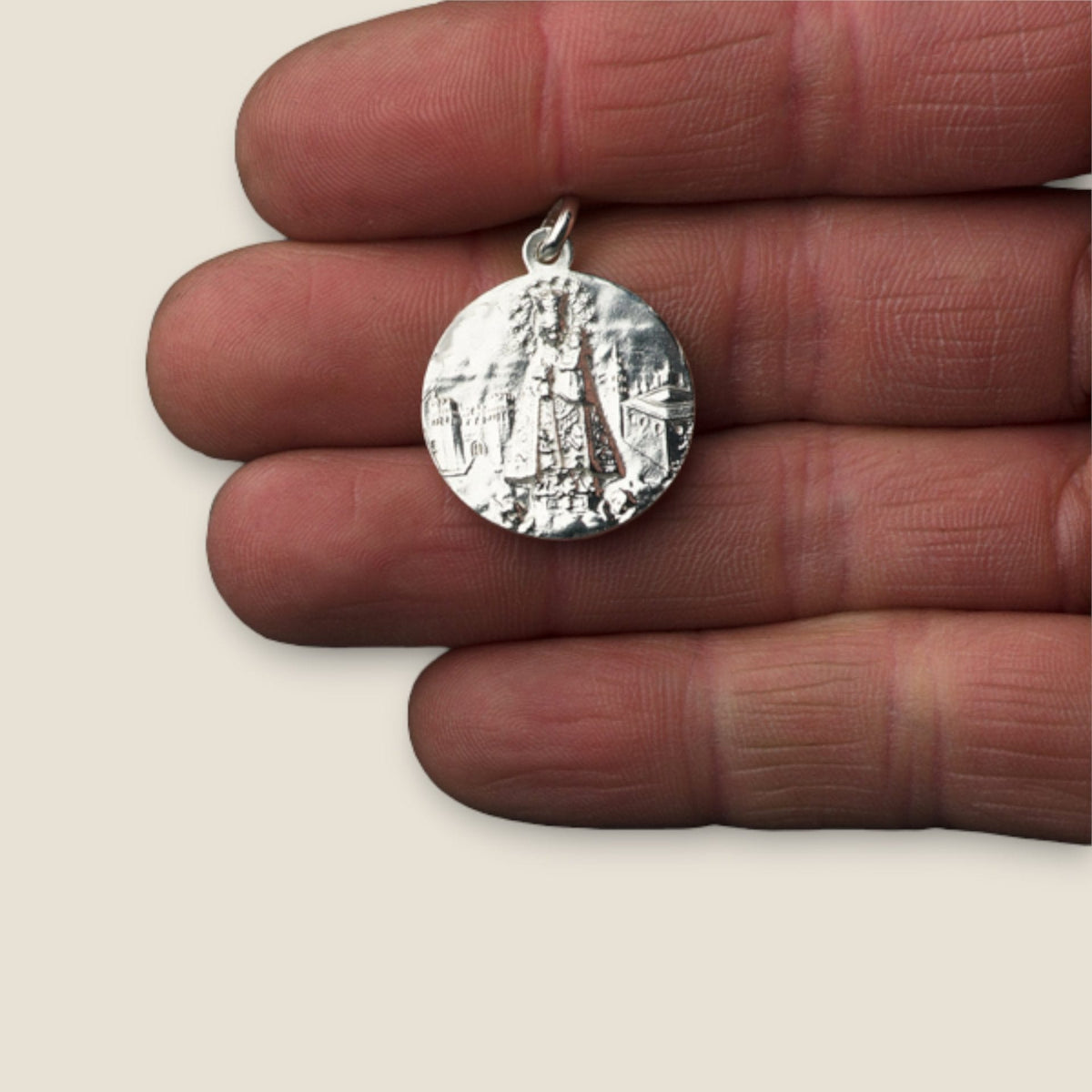 Medalla de Nuestra Señora de los Desamparados en plata - sobre una mano