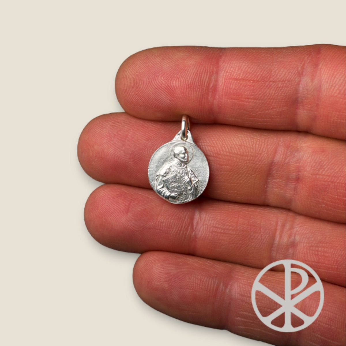Medalla de San Ignacio de Loyola en plata - sobre una mano