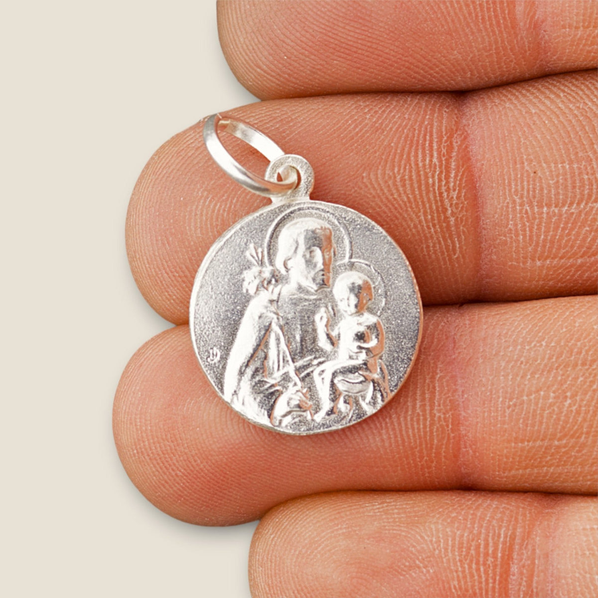 Medalla de San José y Ángel de la Guarda en plata - 17mm sobre una mano