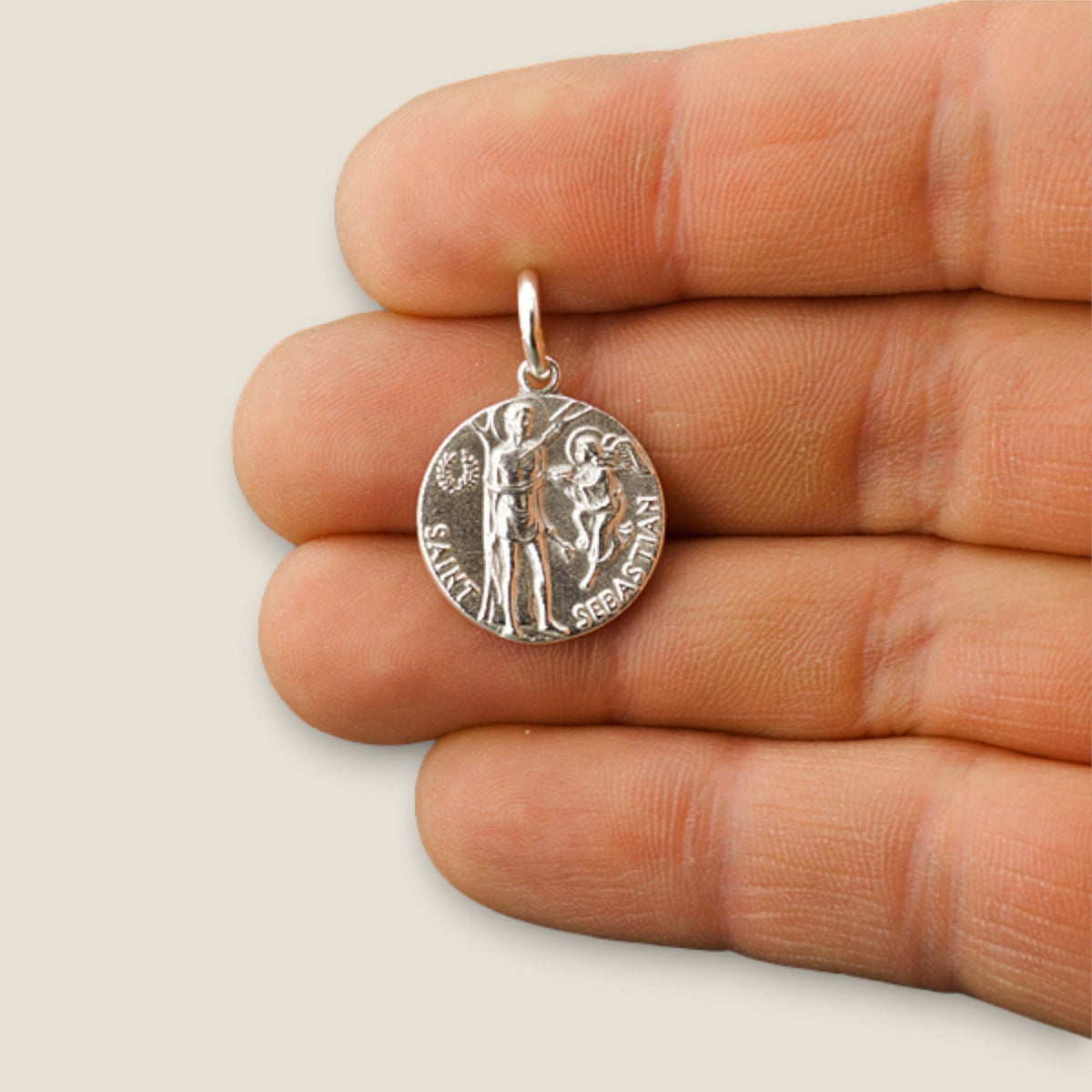 Medalla de San Sebastián en plata - sobre una mano