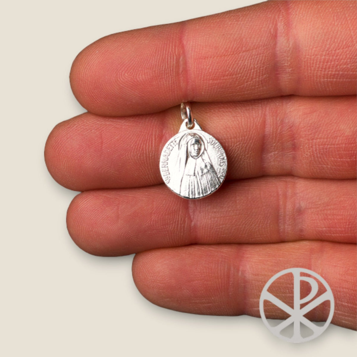 Medalla de Bernadette Soubirous en plata - sobre una mano