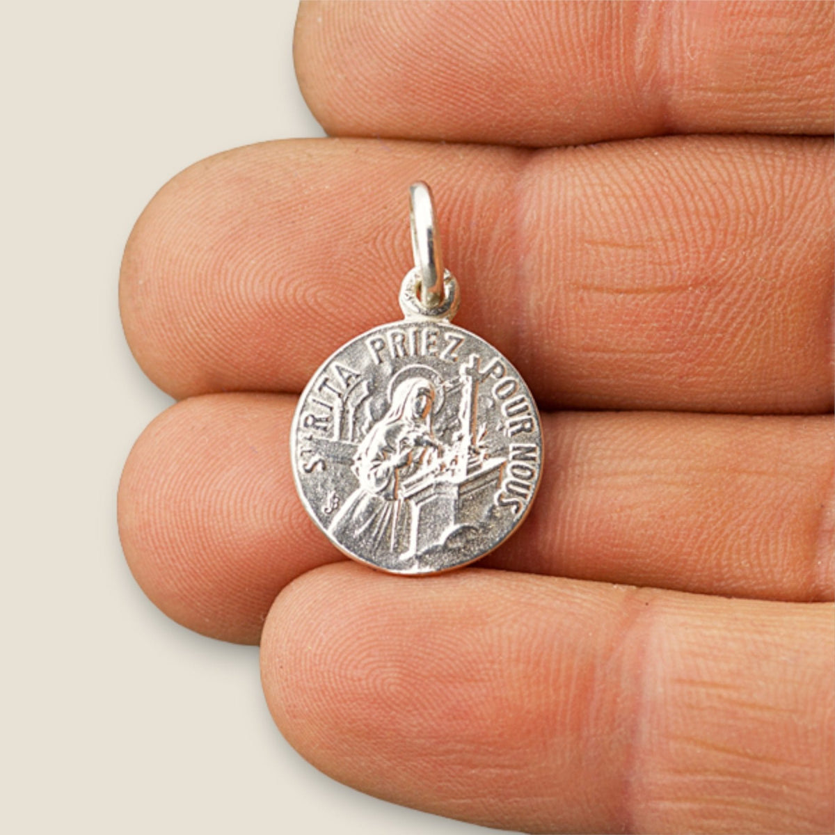 Medalla de Santa Rita y San Antonio de Padua en plata - 16mm sobre una mano