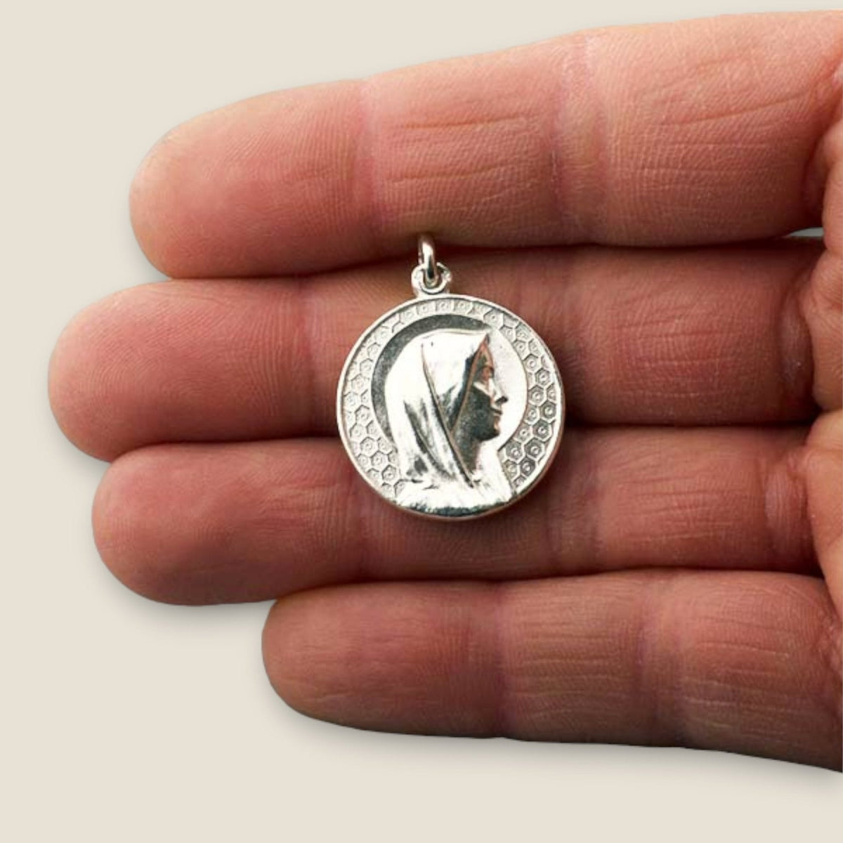Medalla de la Virgen María en plata - sobre una mano