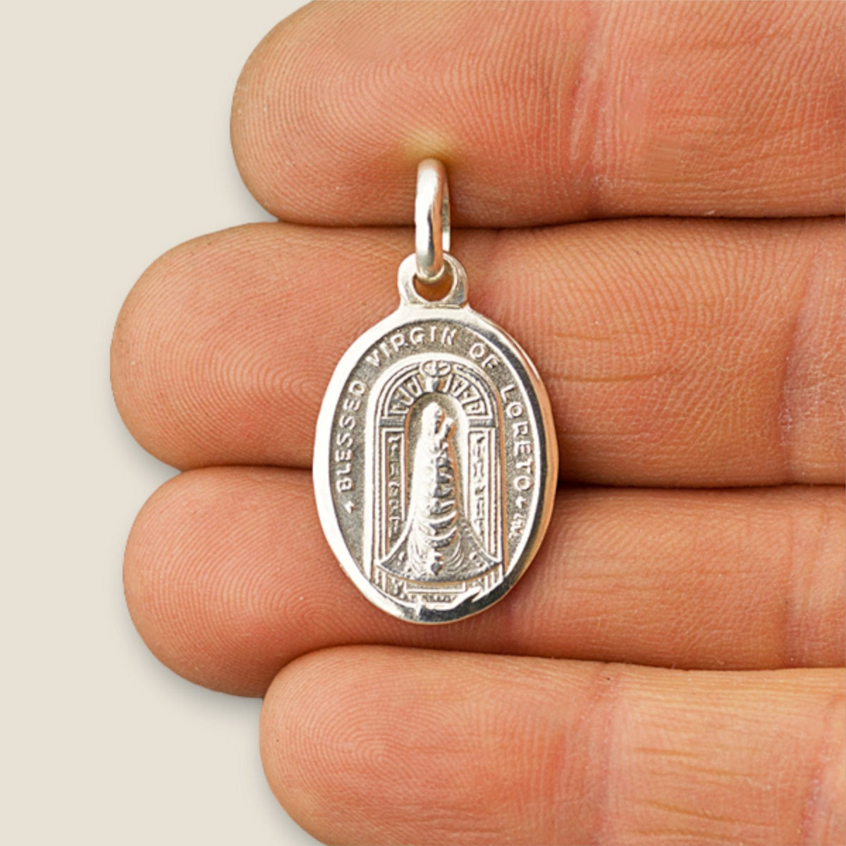 Medalla de la Virgen de Loreto en plata - sobre una mano