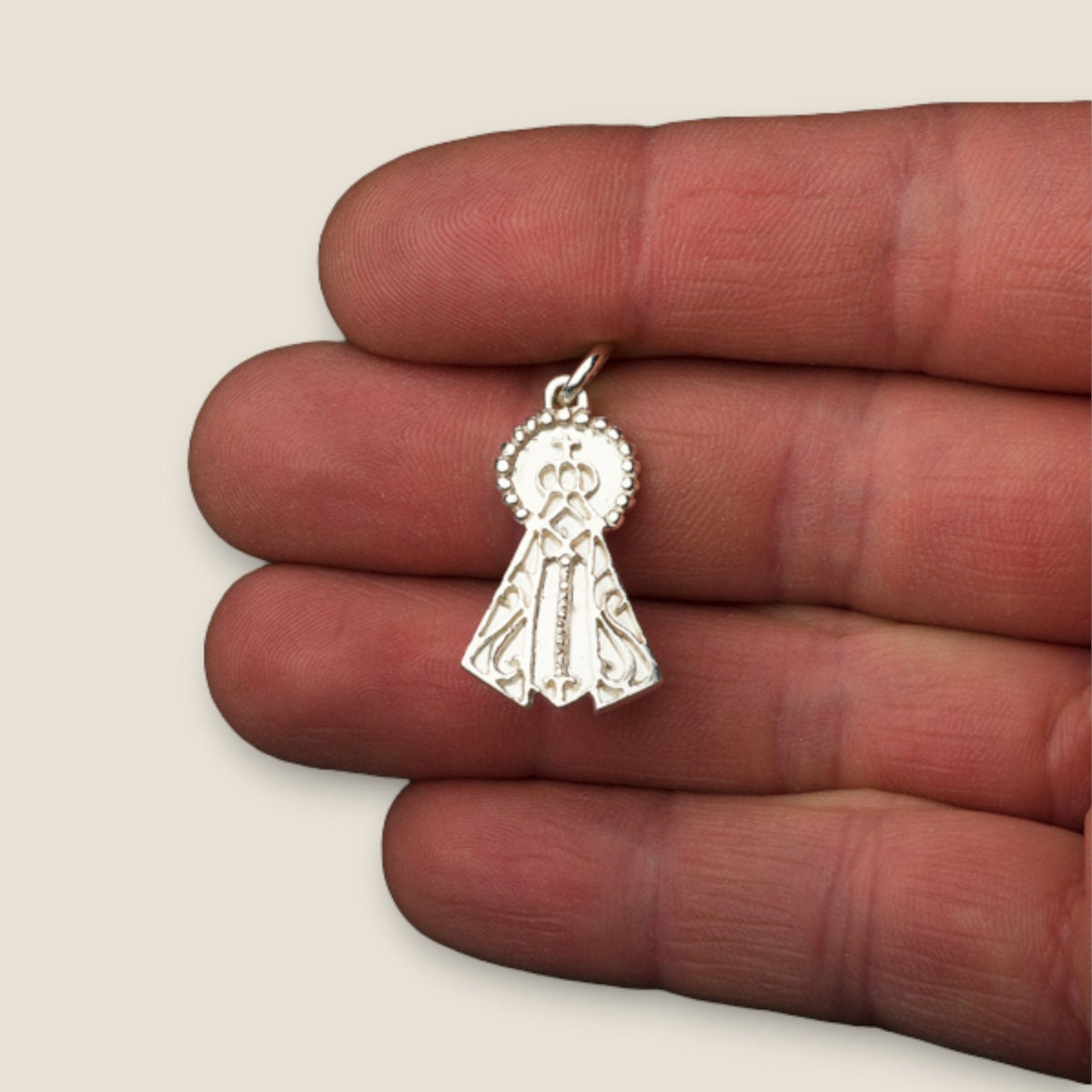 Medalla de la Virgen del Valle en plata - sobre una mano