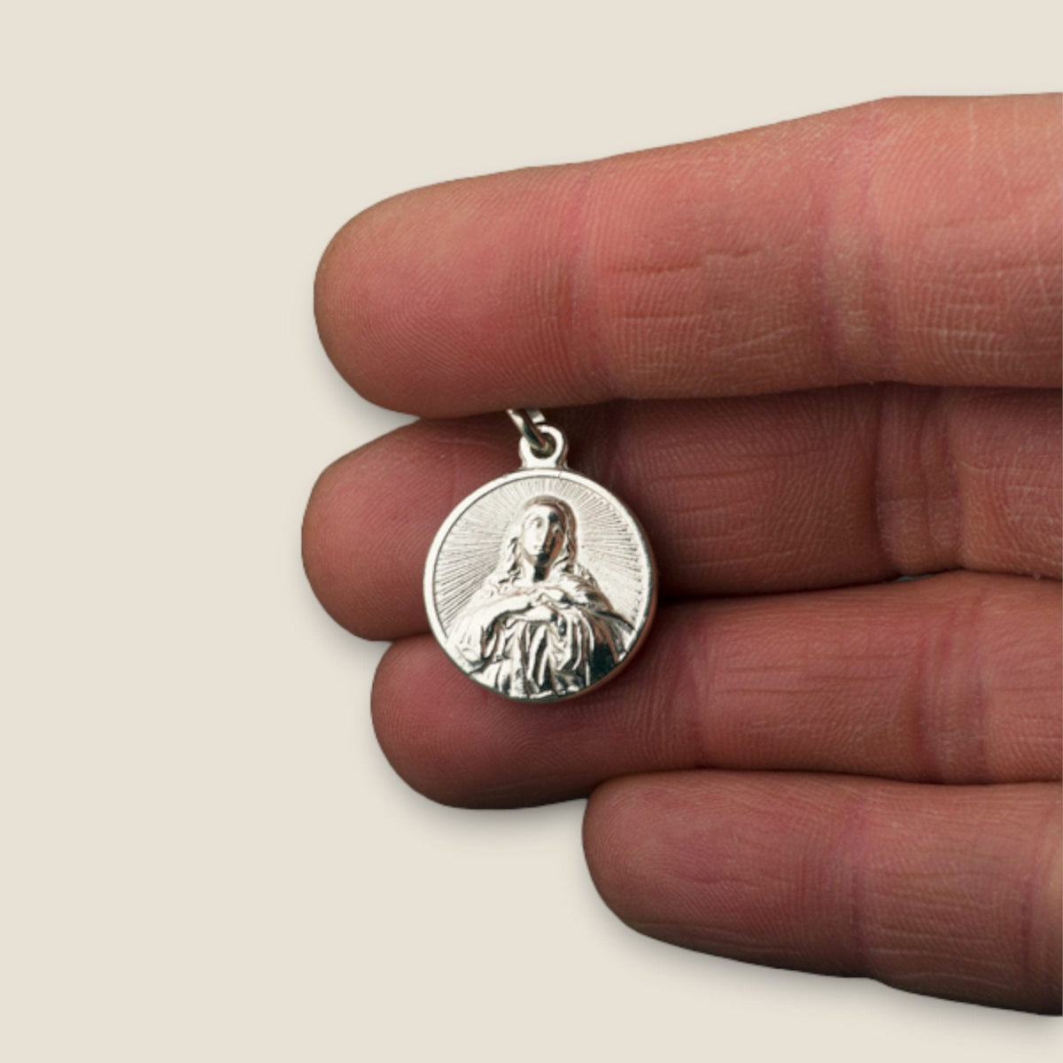 Medalla de la Virgen Inmaculada en plata - sobre una mano