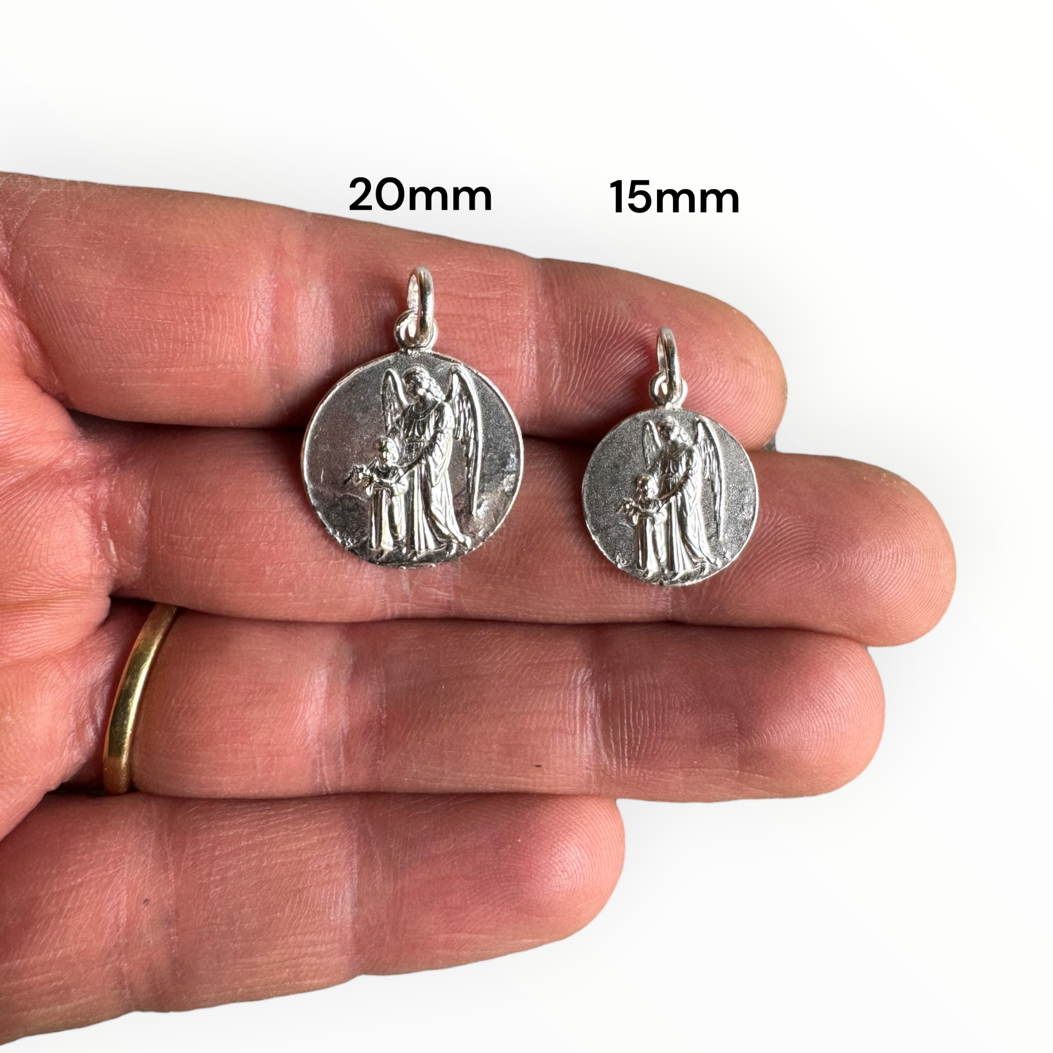 medalla del angel de la guarda de plata fabricada en chile sobre una mano