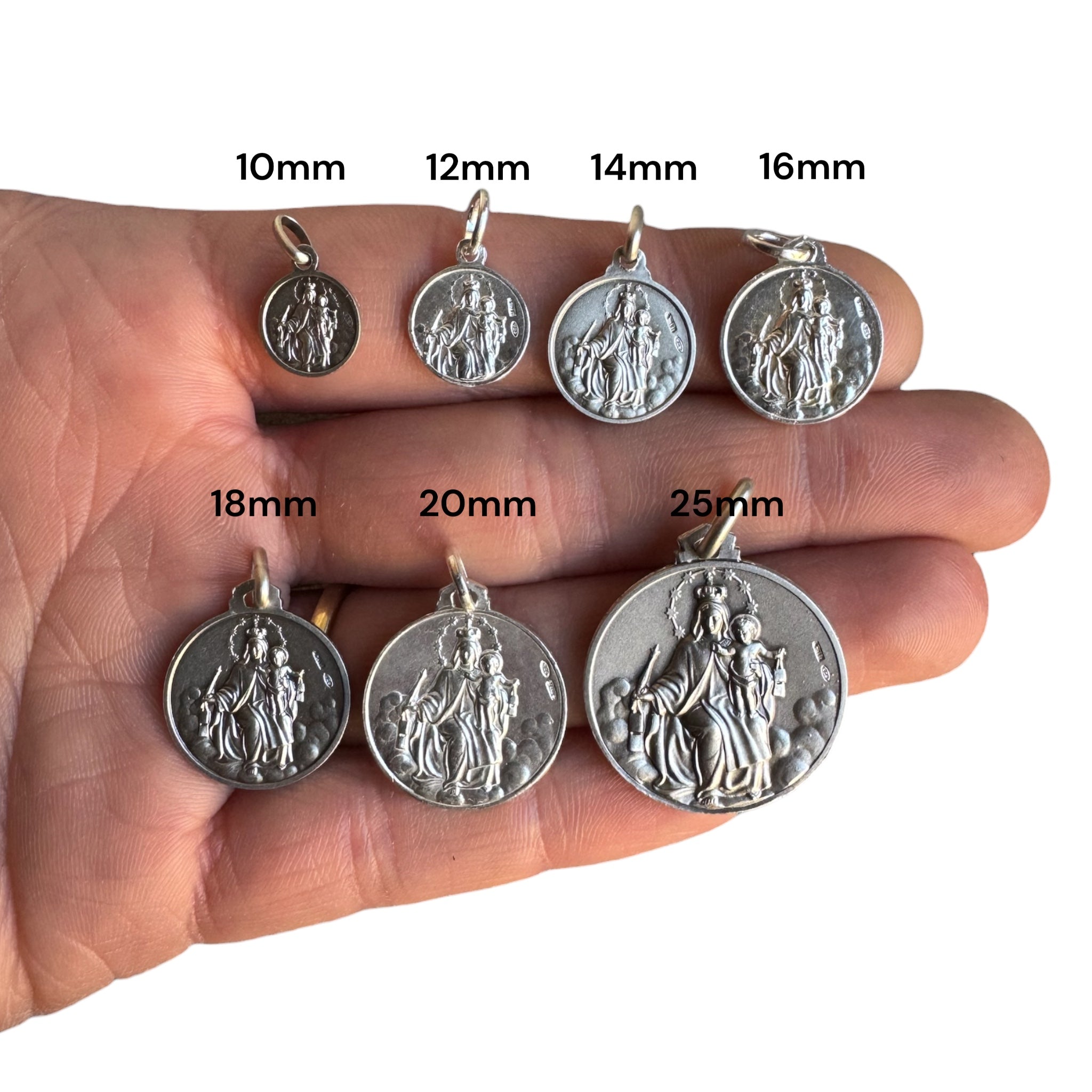 medalla escapulario de la virgen de carmne y el sagrado corazón de jesús en plata comparadas en una mano