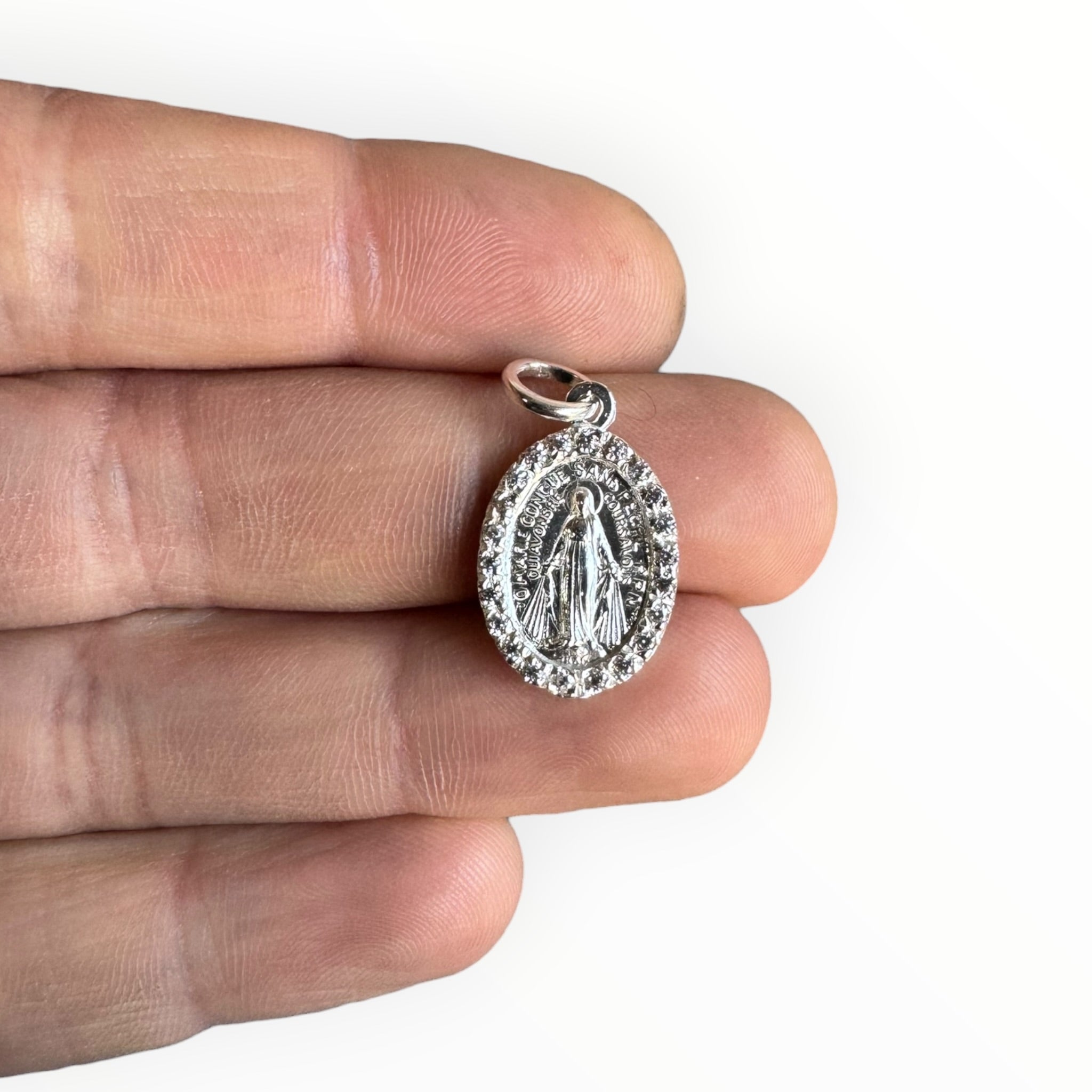 Medalla Milagrosa de la Virgen de los Rayos de plata con Circones sobre una mano