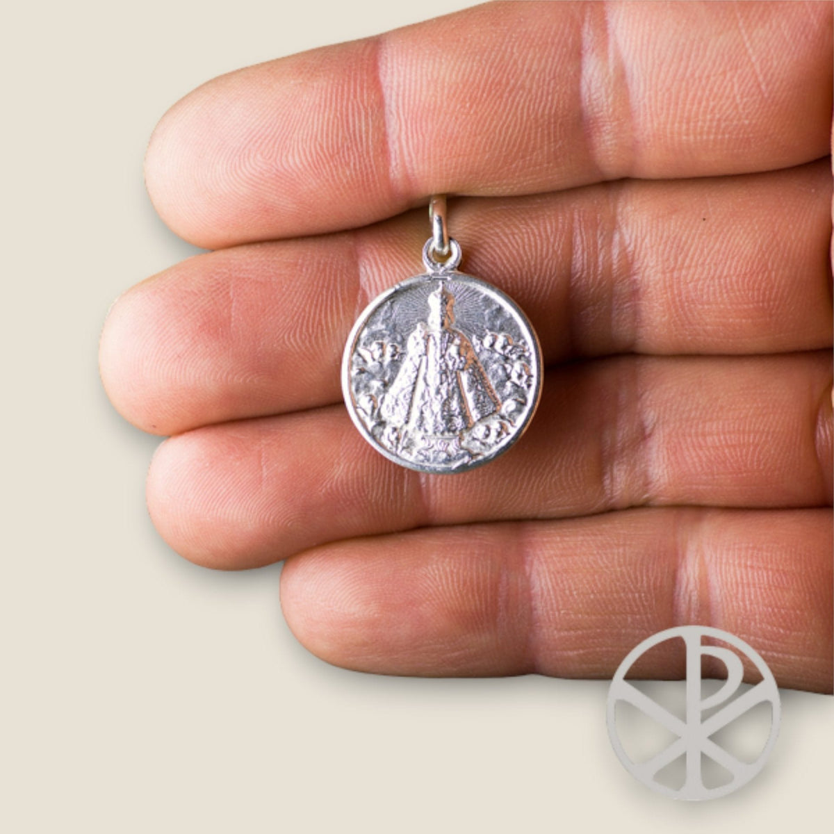 Medalla del Niño Jesús de Praga en plata - sobre una mano