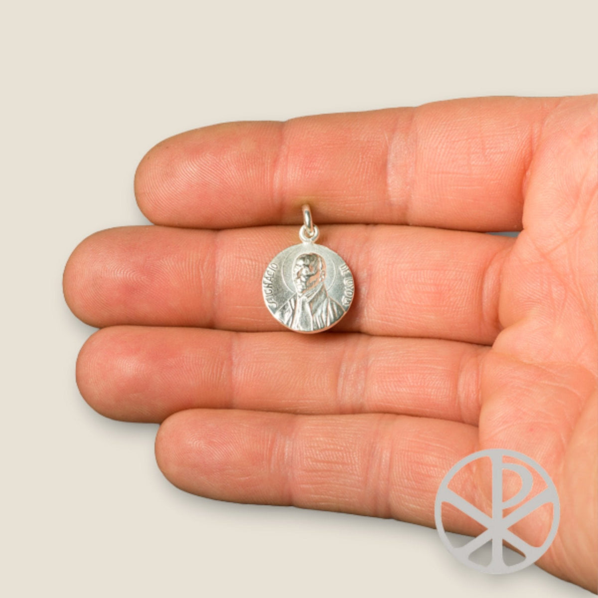 Medalla de San Ignacio de Loyola en plata - sobre una mano