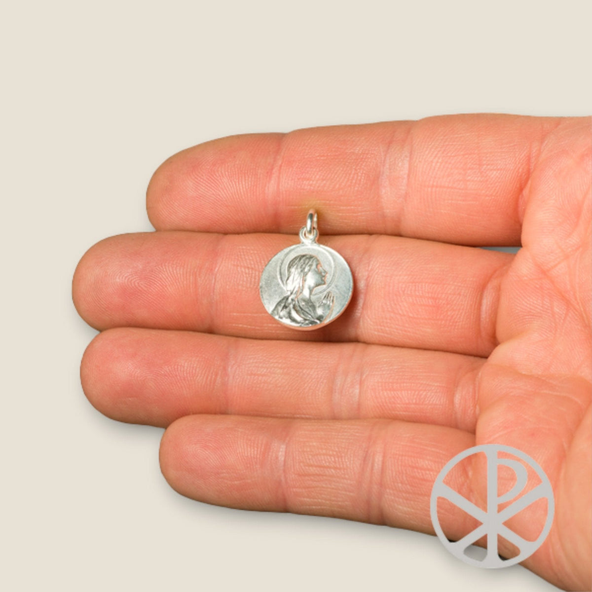 Medalla de la Virgen Niña Orando en plata - sobre una mano