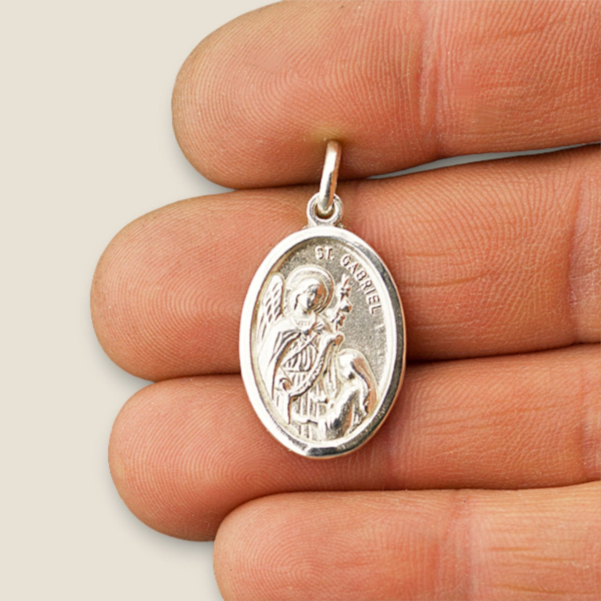 Medalla del Arcángel Gabriel Ovalada en plata - sobre una mano
