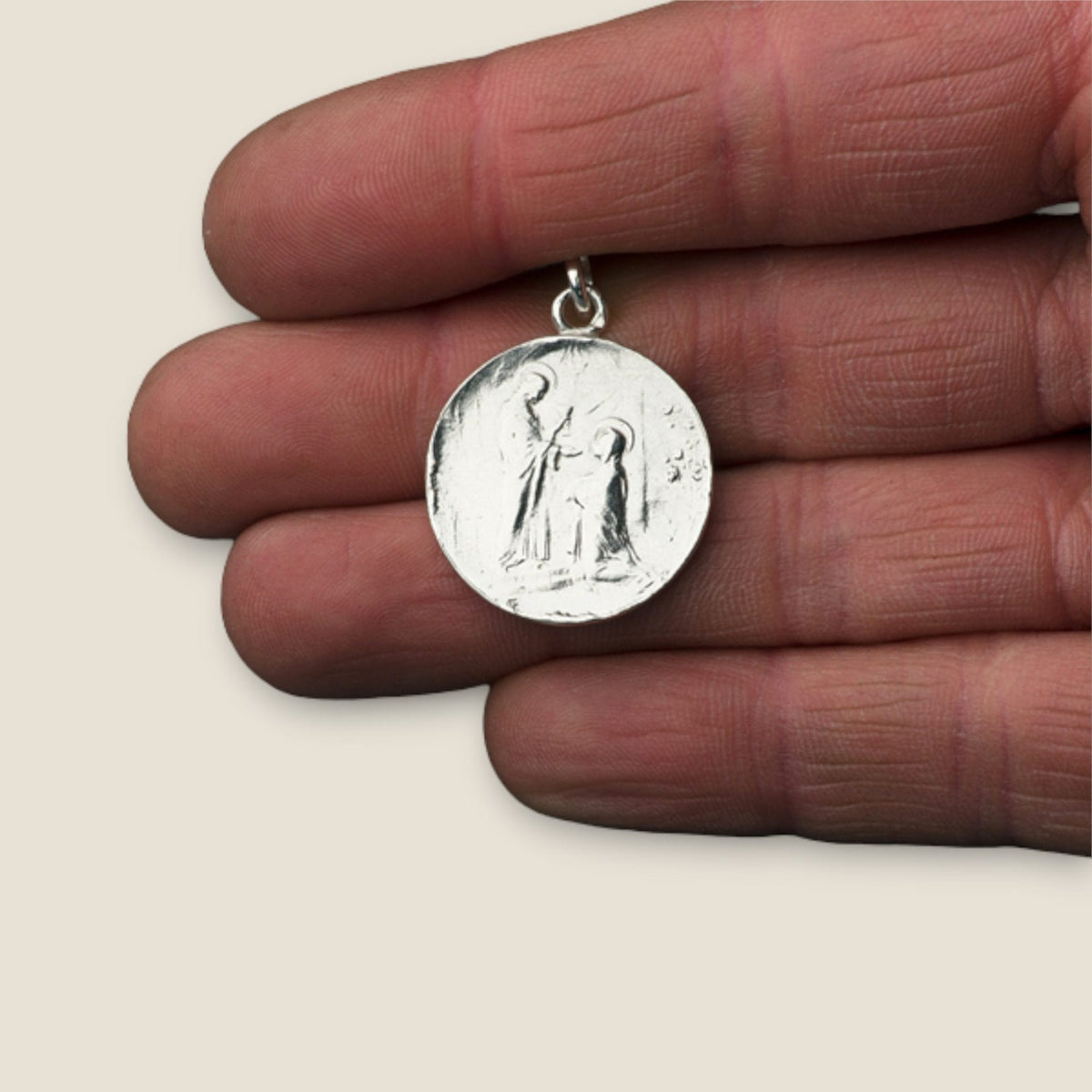 Medalla de la Sagrada Comunión en plata - sobre una mano