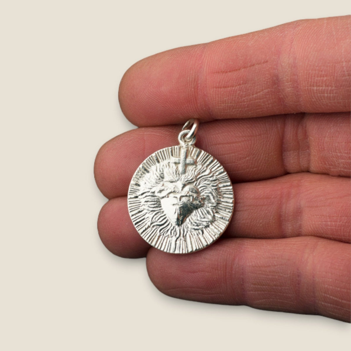 Medalla del Sagrado Corazón de Jesús en plata - tamaño pequeño sobre una mano