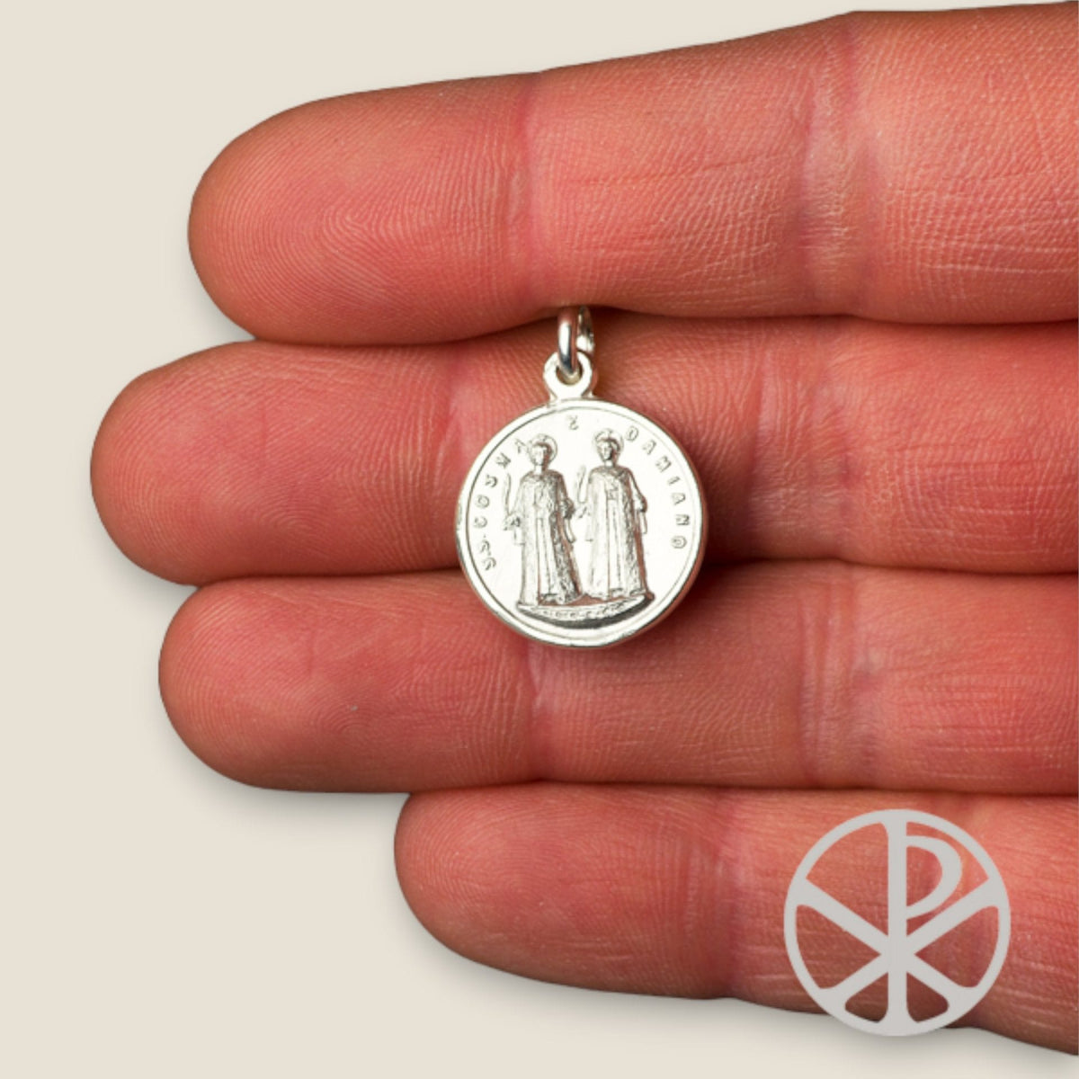 Medalla de San Cosme y San Damián en plata - sobre una mano