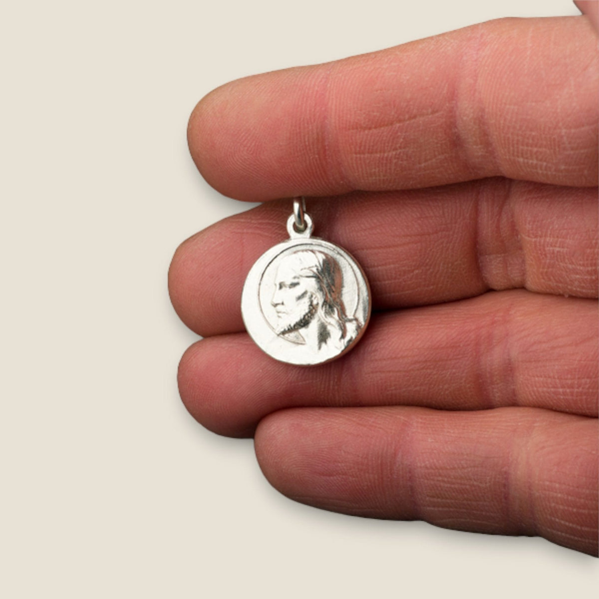 Medalla de Cristo Redentor en plata - sobre una mano
