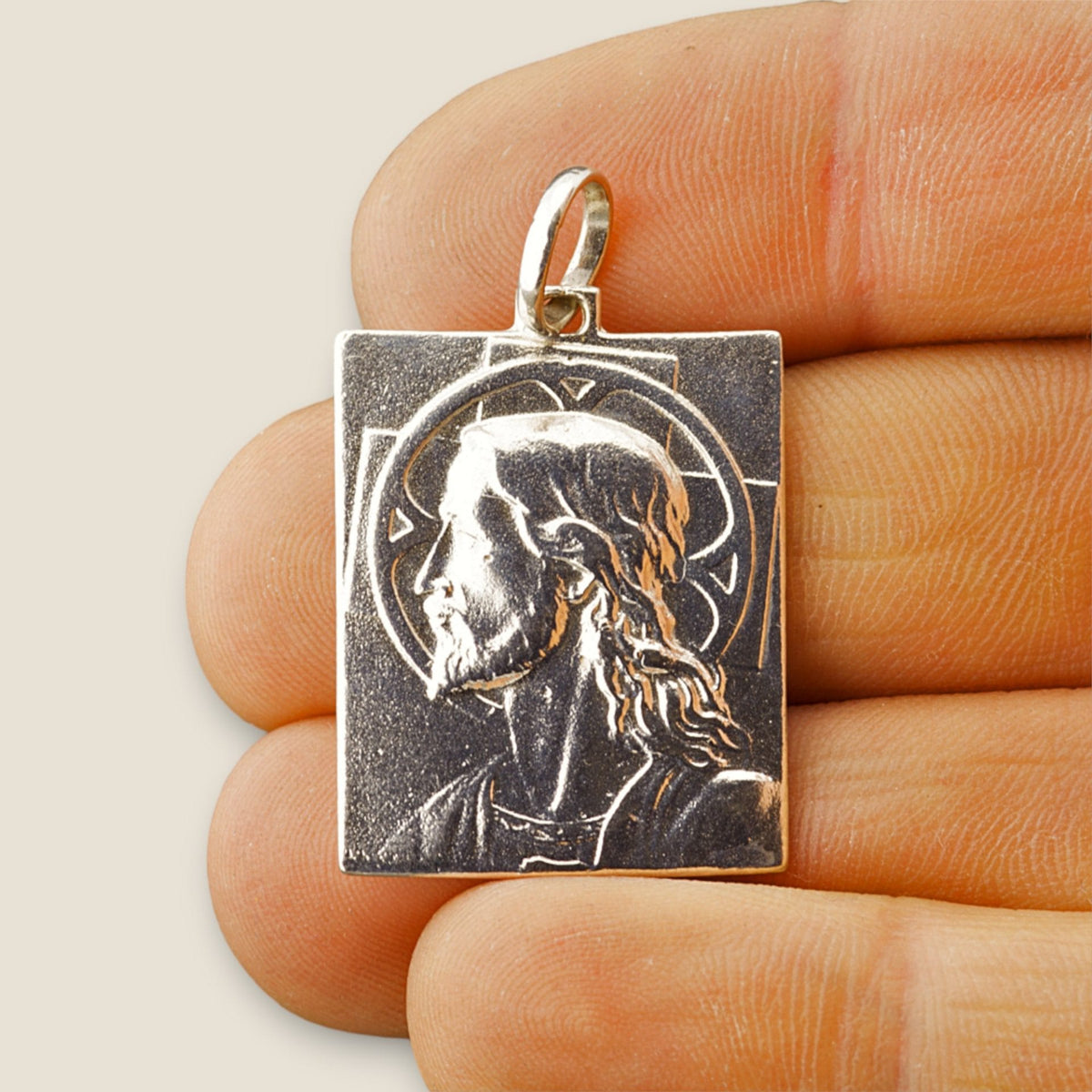 Medalla del Divino Rostro de Jesús en plata - sobre una mano