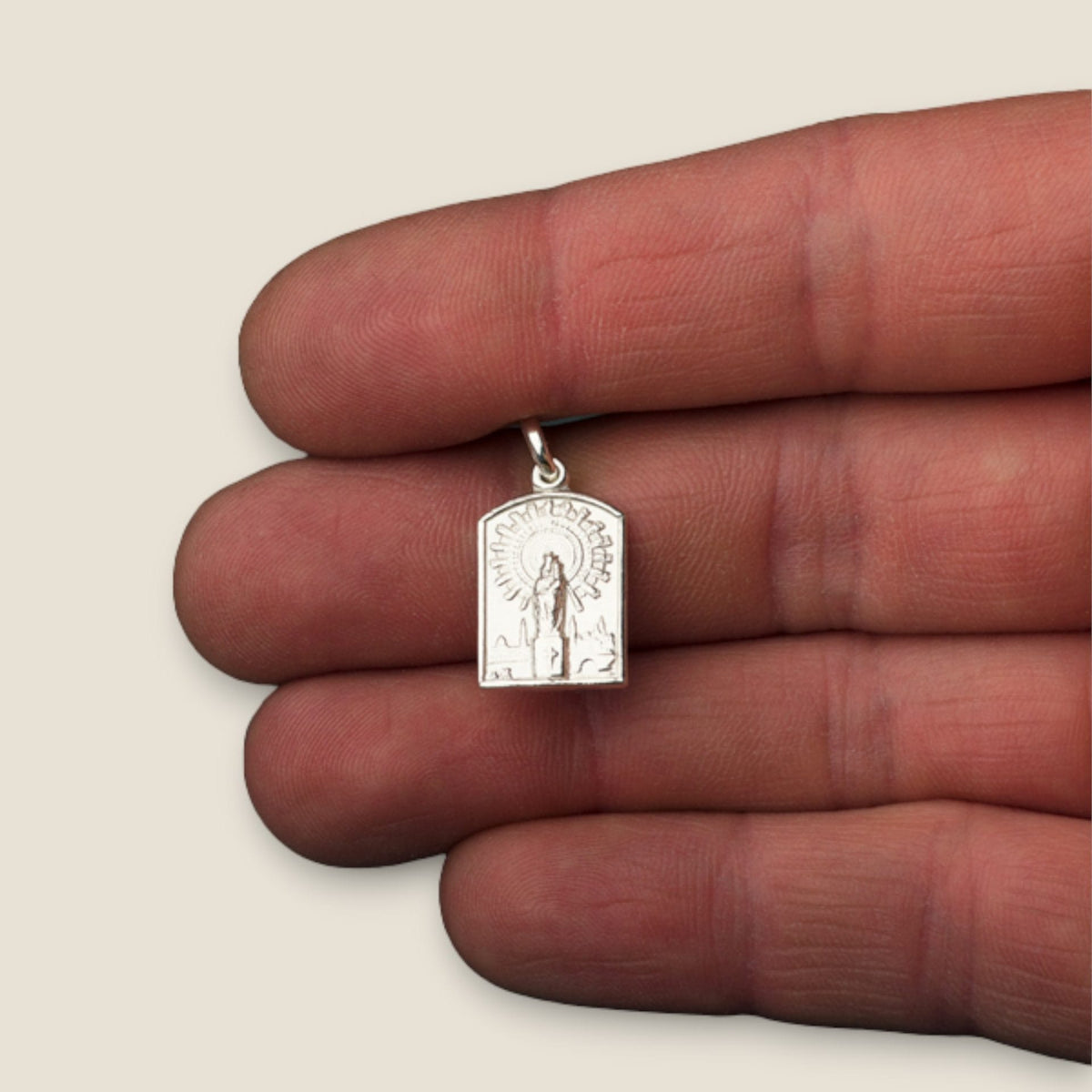 Medalla Escapulario de la Virgen del Pilar y Sagrado Corazón de Jesús en plata - sobre una mano