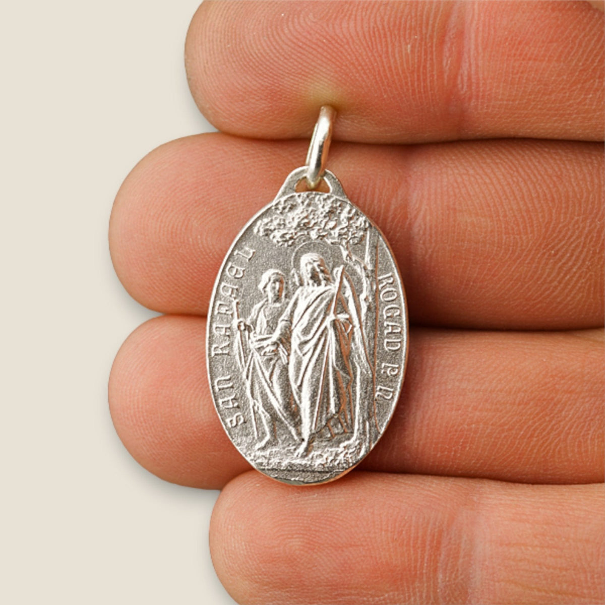Medalla de San Rafael y Virgen del Pilar en plata - sobre una mano