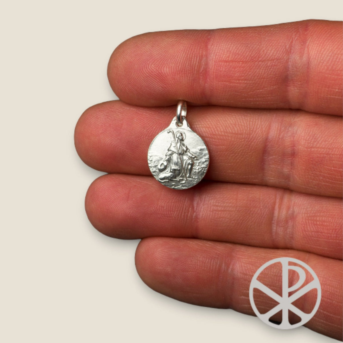 Medalla de San Roque en plata - sobre una mano