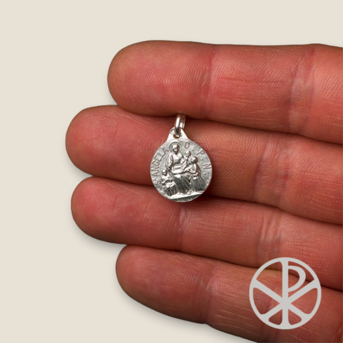 Medalla de Santa Ángela en plata - sobre una mano