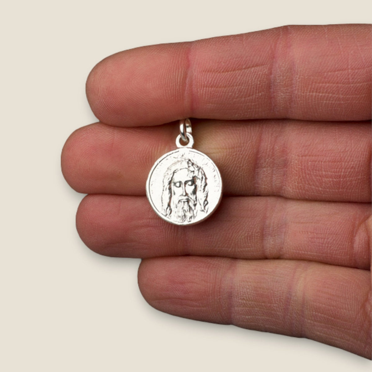 Medalla de la Faz de Cristo en plata - sobre una mano