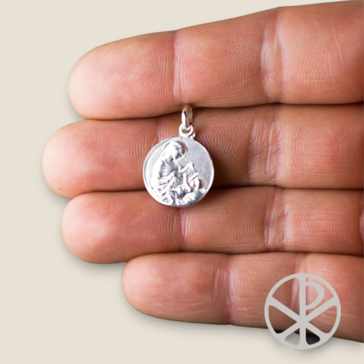 Medalla de la Virgen Maternal en plata - sobre una mano