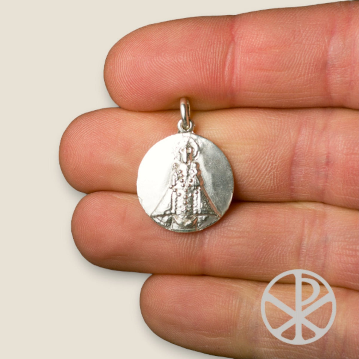 Medalla de la Virgen de Andacollo en plata - sobre una mano