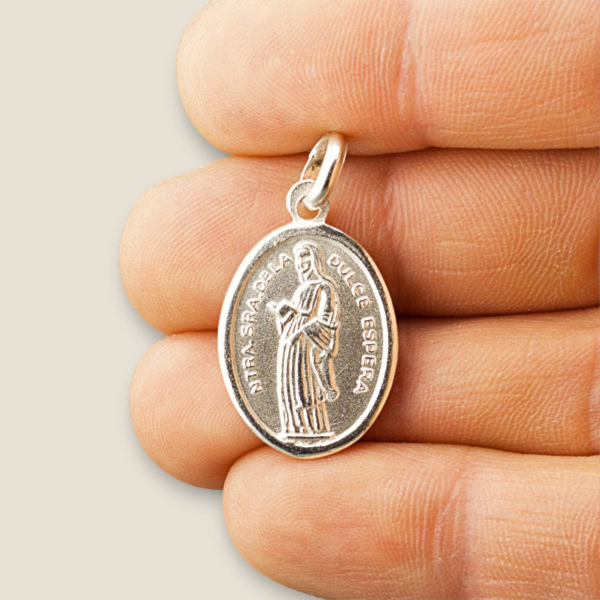 Medalla de la Virgen de la Dulce Espera en plata - sobre una mano