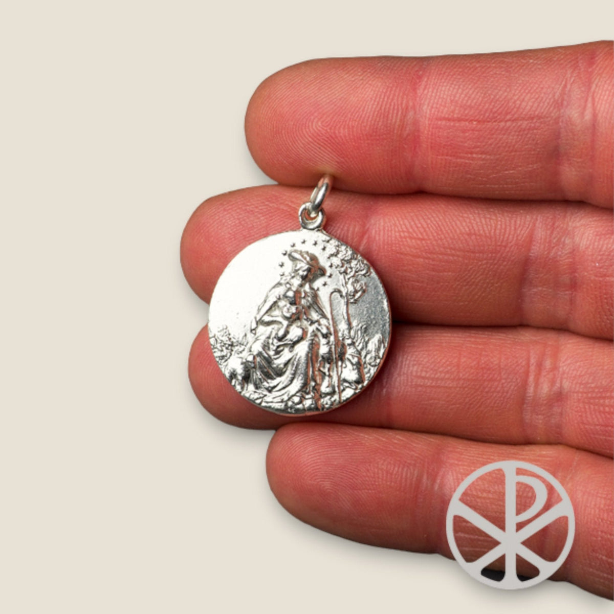 Medalla de la Virgen Divina Pastora y Sagrado Corazón en plata - sobre una mano