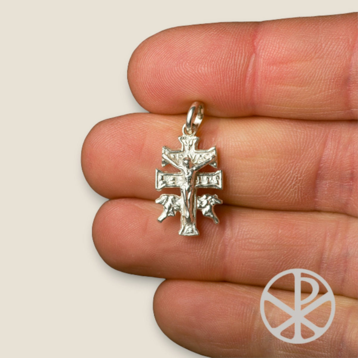 Cruz de Caravaca en plata - chica sobre una mano