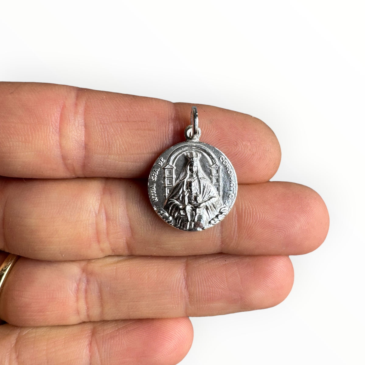 Medalla de Nuestra señora de Coromoto en plata sobre una mano
