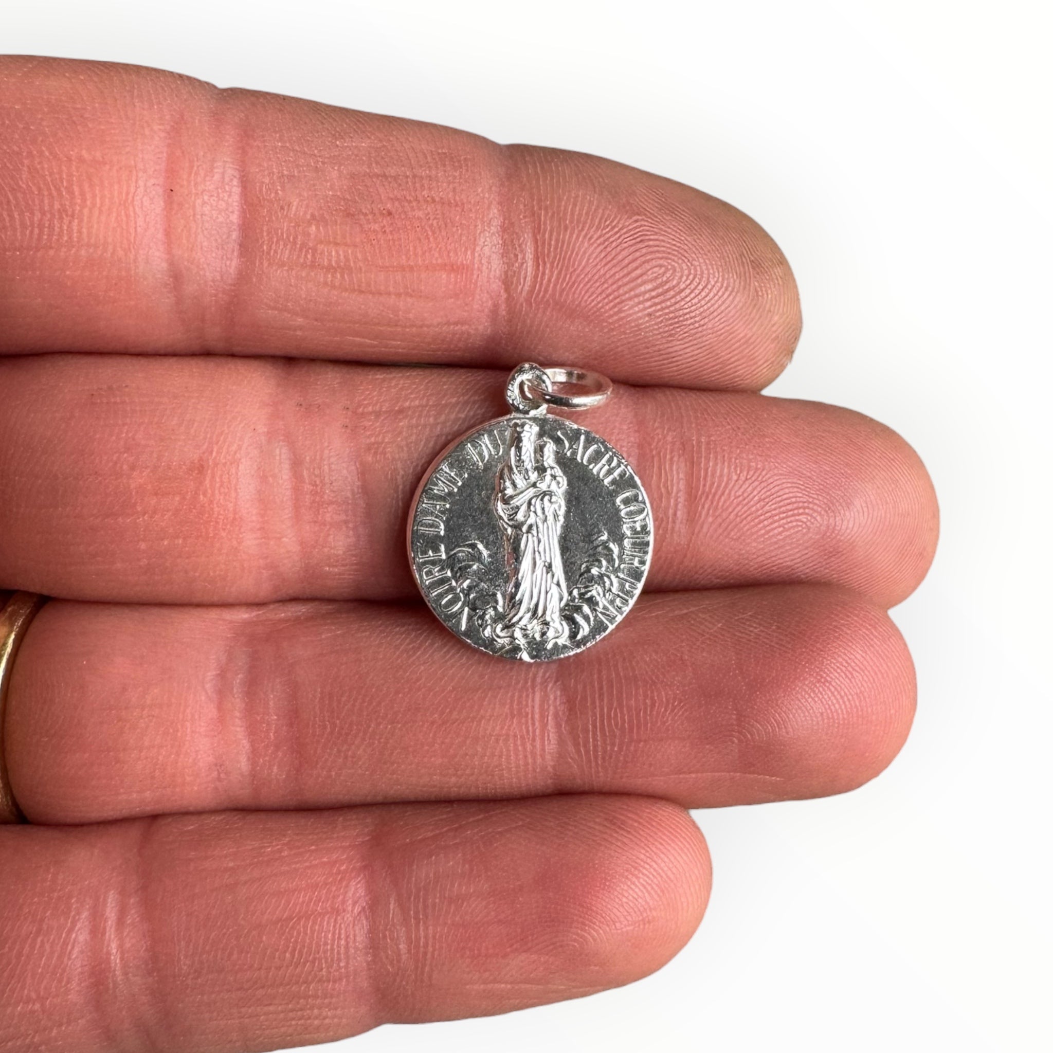 Medalla Escapulario Nuestra Señora del Sagrado Corazón sobre una mano