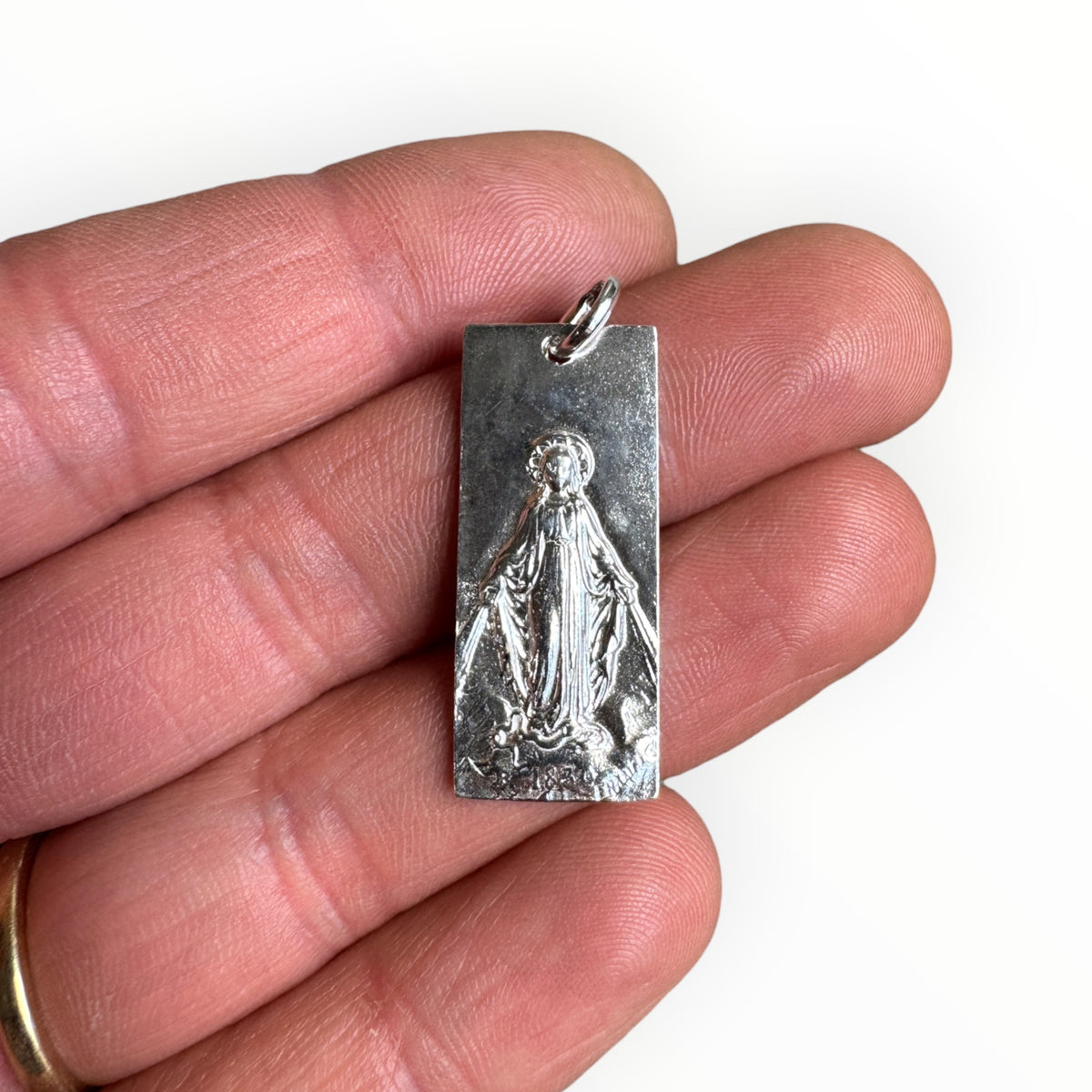 Medalla rectangular de la Virgen de los Rayos en plata 950 Sobre una mano