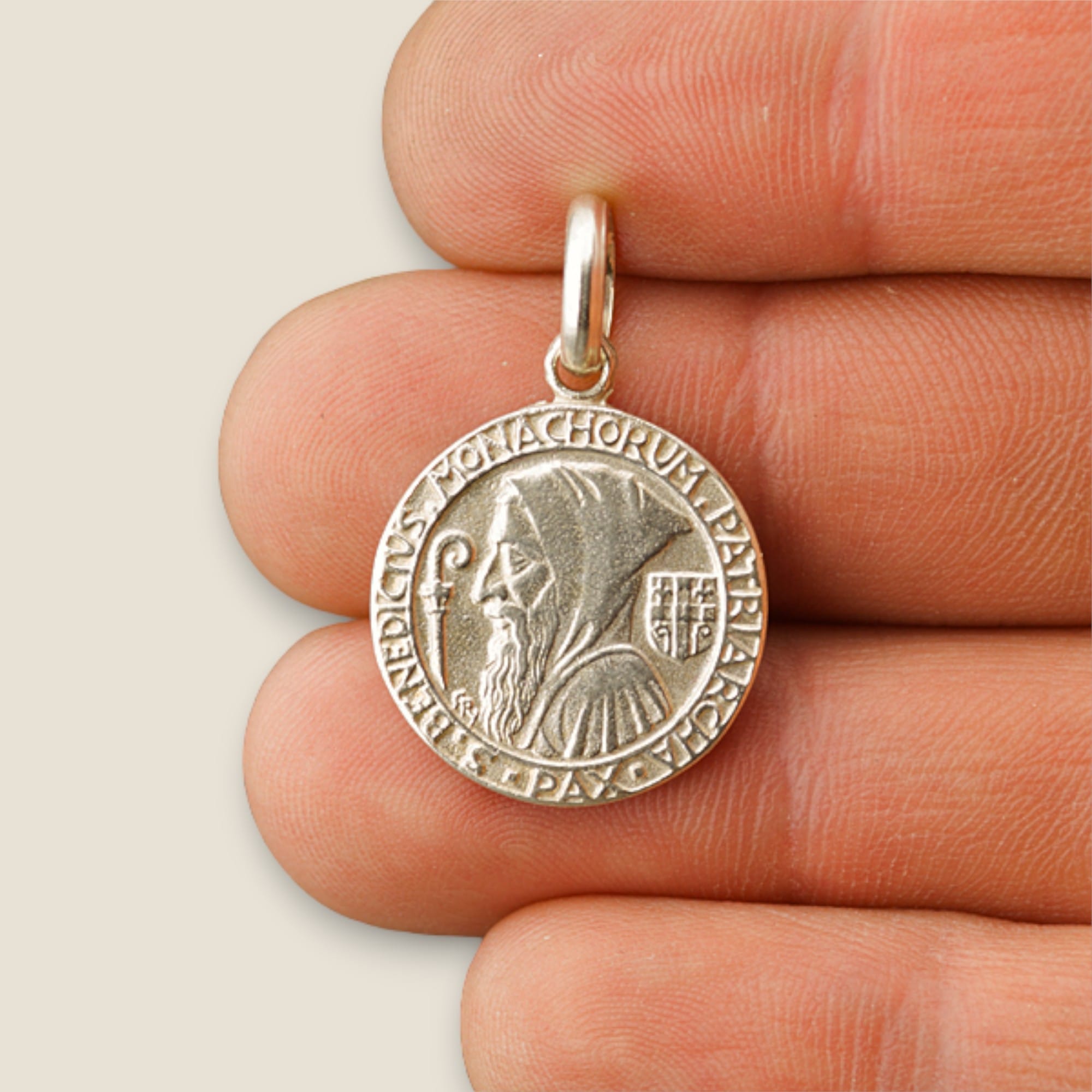 Medalla de San Benito de Perfil en plata 950 - 19mm sobre una mano