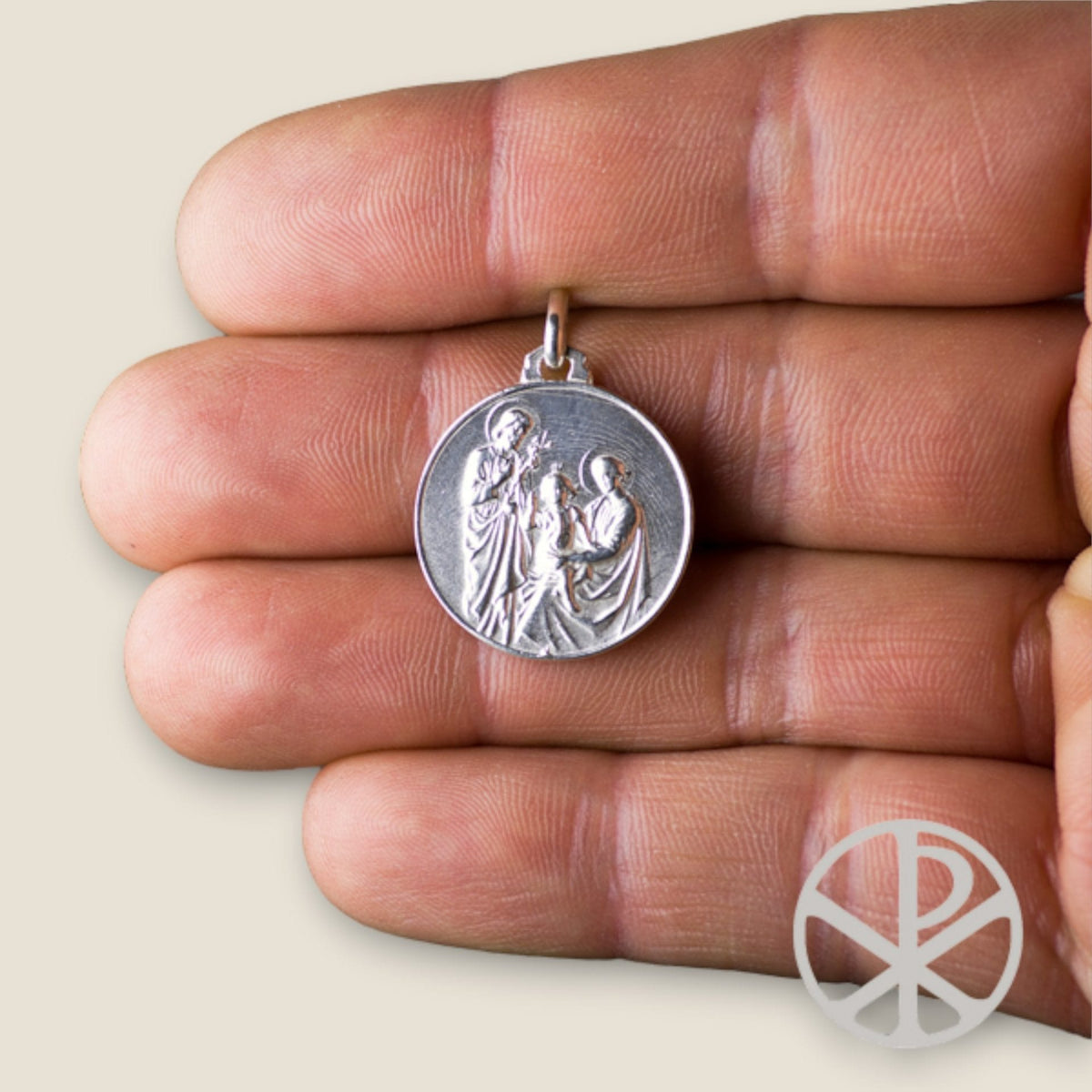 Medalla de la Sagrada Familia en plata - sobre una mano