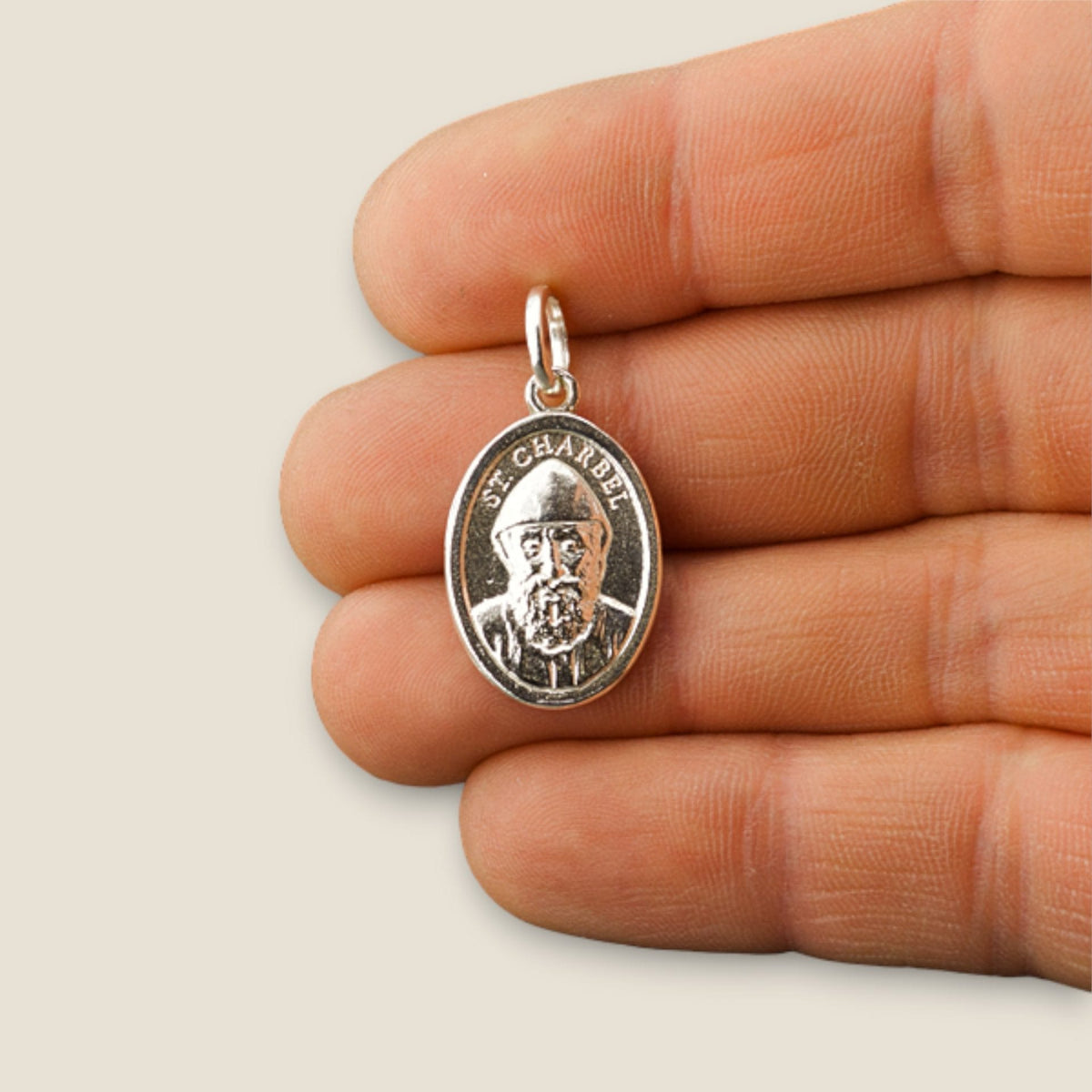 Medalla de San Charbel en plata - sobre una mano